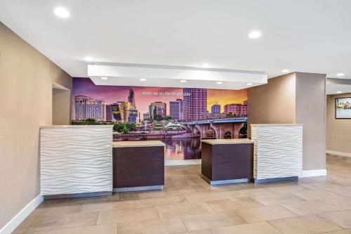 a lobby with a large mural of a city at La Quinta by Wyndham Hartford Bradley Airport in Windsor Locks