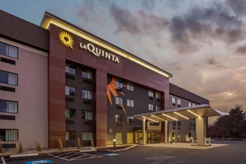 a hotel with a sign on the side of it at La Quinta by Wyndham Hartford Bradley Airport in Windsor Locks