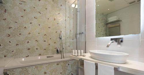 a bathroom with a sink and a mirror and a tub at Hotel Villa Blu Capri in Anacapri