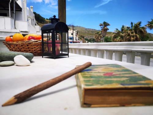 a wooden stick and a basket of fruit on a table at By the sea in Andros