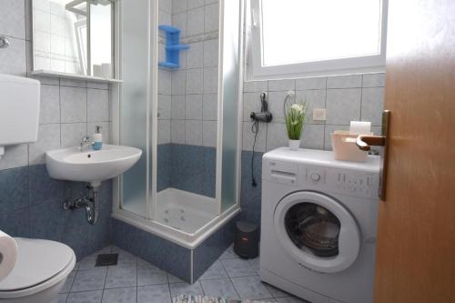a bathroom with a washing machine and a sink at Apartment Sunny 1 in Njivice