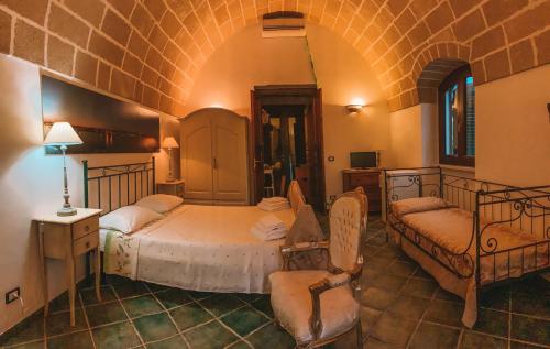 1 dormitorio con 2 camas y 1 silla en Agriturismo Baccole, en Gagliano del Capo