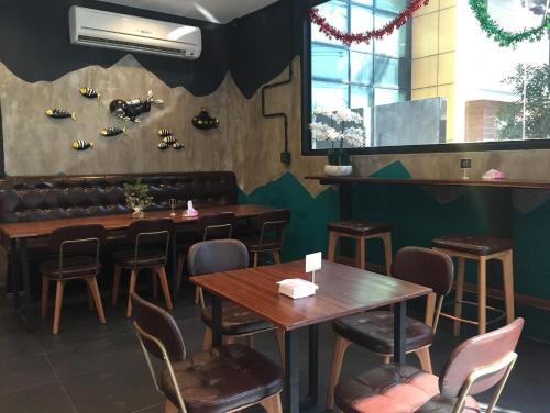 a restaurant with tables and chairs and a bench at Airport Mini Hostel at Don Muang Airport in Ban Don Muang