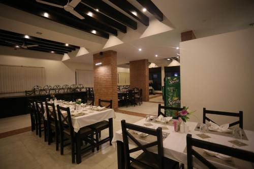 a dining room with white tables and chairs at Hotel Ananda Inn in Lumbini