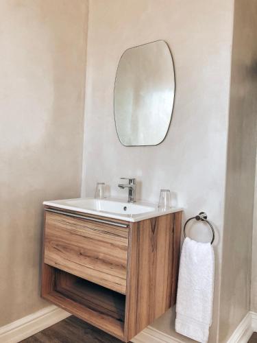 a bathroom with a sink and a mirror at Chateau de Marine Boutique Hotel in Struisbaai