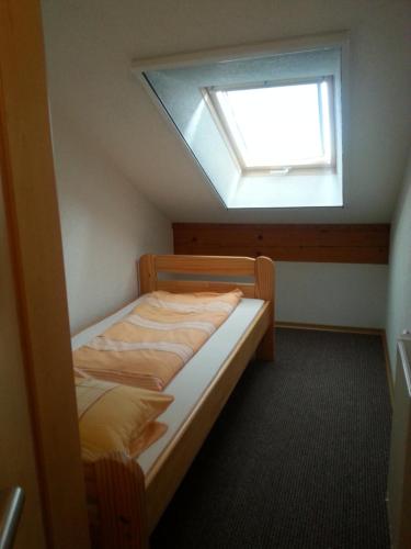 a small bedroom with a bed with a skylight at Ferienhof am Nationalpark in Schöneberg