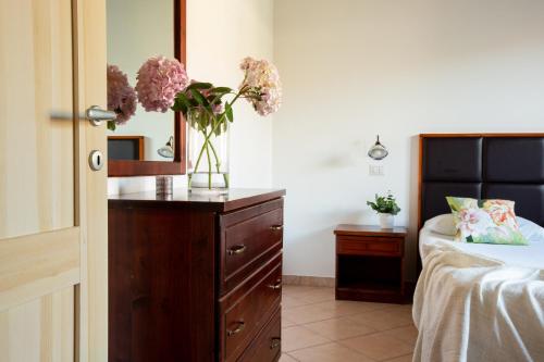 a bedroom with a bed and a vase of flowers on a dresser at Borgo Verde in Vada