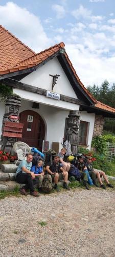 a group of people sitting in front of a house at Camping Konradówka in Olecko