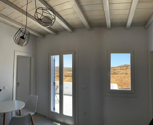 a dining room with a table and two windows at Miamis Villas Mykonos II in Mikonos