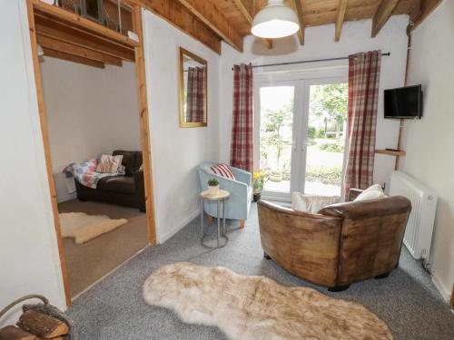 a living room with a chair and a couch at Little House in Beaumaris