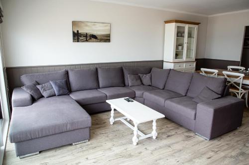 a living room with a couch and a table at Bed & Beach Sydney in Middelkerke