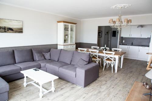 a living room with a couch and a table at Bed & Beach Sydney in Middelkerke