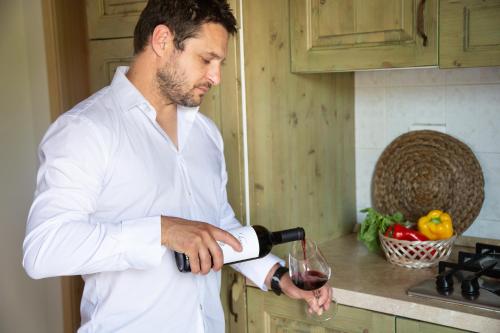 a man pouring a glass of wine in the kitchen at Borgo Verde in Vada
