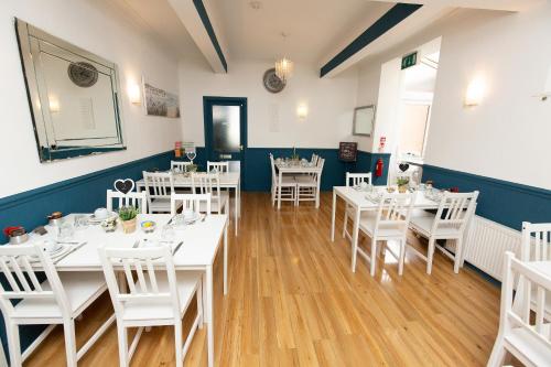 a dining room with white tables and white chairs at The Carlton in Blackpool