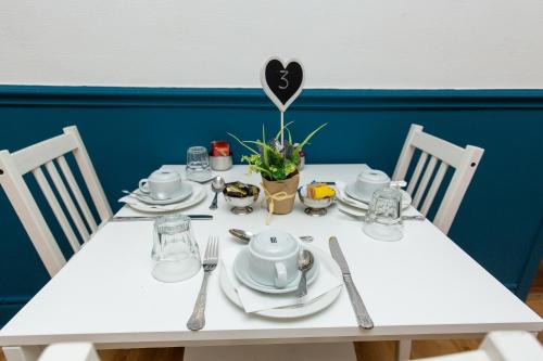 - une table blanche avec des assiettes et des ustensiles dans l'établissement The Carlton, à Blackpool