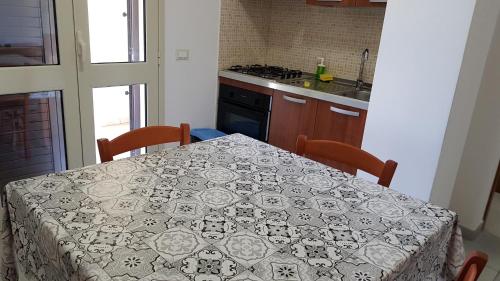 a kitchen with a table with a table cloth on it at Residence Catona in Otranto