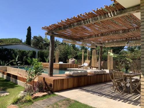 un patio avec une pergola à côté d'une piscine dans l'établissement Villa Casa del Hort, Private Pool & Garden, à Sant Martí d’Empúries