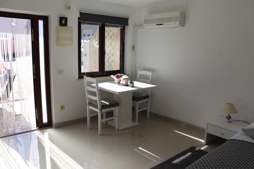 een kleine kamer met een witte tafel en stoelen bij an Amazing Studio Apartment in Premantura