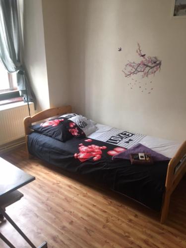 a bed in a room with a wooden floor at Penzion Willa in Jihlava