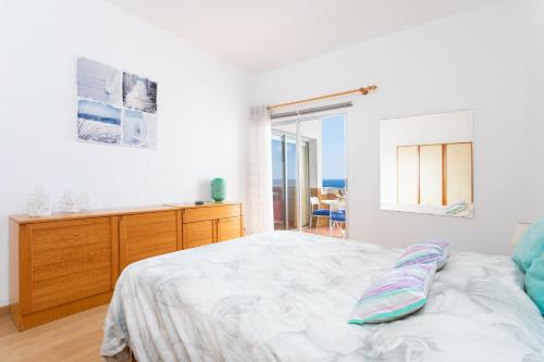 a white bedroom with a bed and a window at Home2Book Playa Chica Paradise Santa Cruz in Santa Cruz de Tenerife
