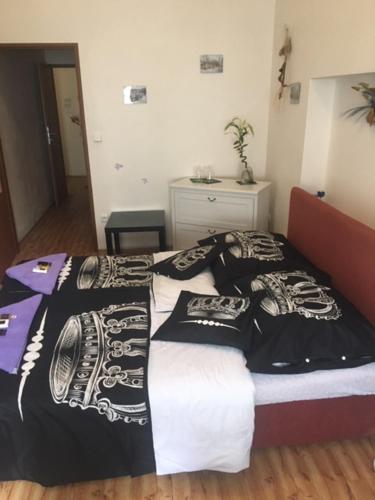 a bedroom with a bed with black and white sheets at Penzion Willa in Jihlava