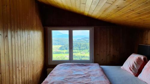 una camera da letto con una grande finestra e un letto di Landgasthof Hölzlisberg a Eichberg
