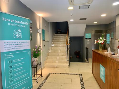 a hallway with stairs and a sign in a building at Hotel Los Templarios in Ponferrada