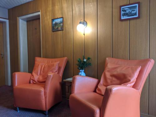 a waiting room with two orange chairs and a table at Montahaus Retro Apartments in Vandans