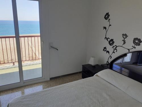 1 dormitorio con cama y vistas al océano en Suitur apartamento primera linea mar vistas playa, en Canet de Mar