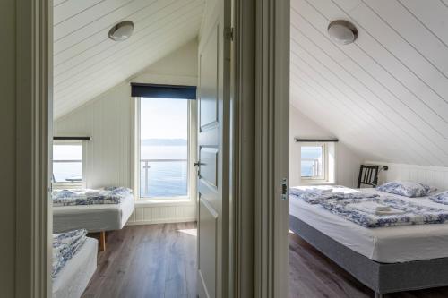 a bedroom with two beds and a window at Hjellup Fjordbo in Leksvik