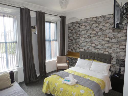 a bedroom with a bed and a stone wall at Princes House in the Walled City in Derry Londonderry