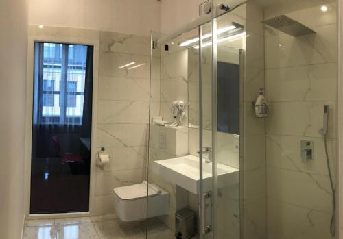 W łazience znajduje się prysznic, umywalka i toaleta. w obiekcie Hotel77 w mieście Zamość