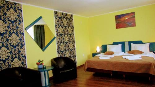a hotel room with a bed and a chair at Casa Leucian in Deva