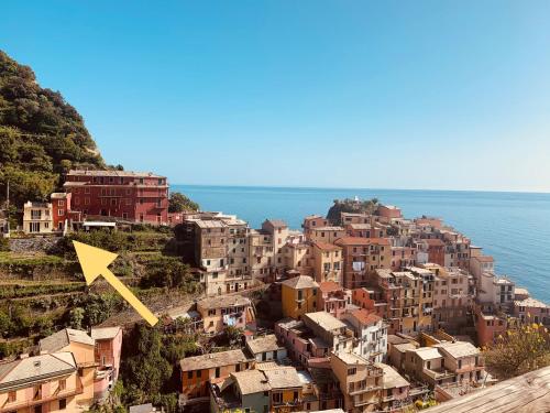 a town on a hill with a yellow arrow at Orizzonti Apartments in Manarola