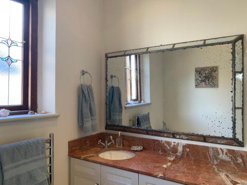 a bathroom with a sink and a large mirror at Whalehaven in Kalk Bay