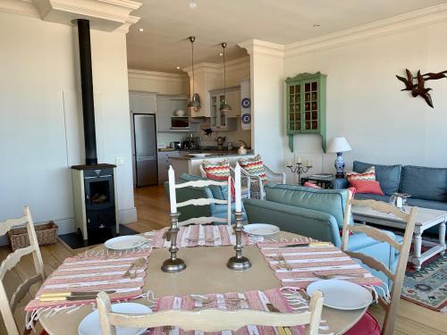 a kitchen and living room with a table and chairs at Whalehaven in Kalk Bay