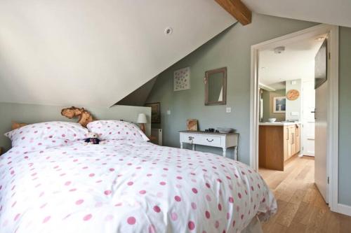Schlafzimmer mit einem Bett mit rosa Polka-Punkten-Bettwäsche in der Unterkunft Bentley Rise in Lyme Regis