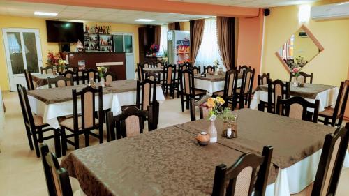 a restaurant with tables and chairs with flowers on them at Casa Leucian in Deva