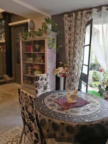 une salle à manger avec une table, des chaises et un oiseau. dans l'établissement Logis l'Estelvin chambres d'hôtes, à Carcassonne