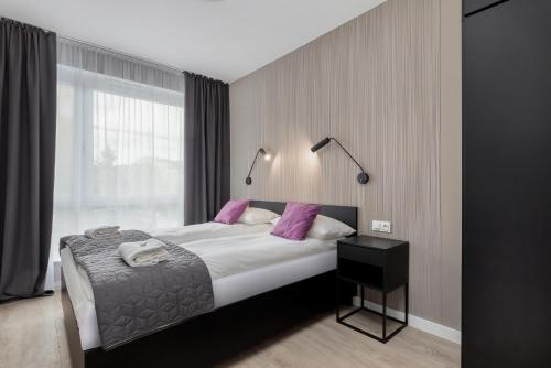 sypialnia z dużym łóżkiem z fioletowymi poduszkami w obiekcie Modern City Center Apartments by Noclegi Renters w Poznaniu