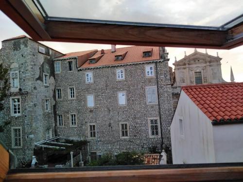 un grand bâtiment en briques avec un toit rouge dans l'établissement Apartments Abjanic, à Dubrovnik