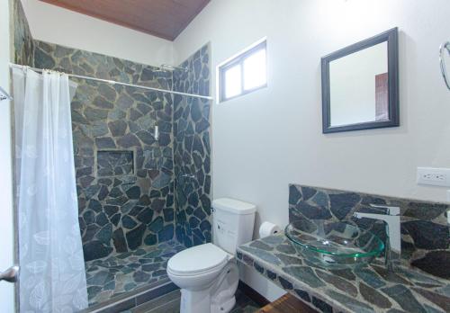 La salle de bains est pourvue de toilettes et d'un lavabo en verre. dans l'établissement Green Habitat, à Monteverde Costa Rica