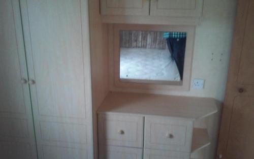 a small bedroom with a bed in a mirror at Hemsby Long Beach in Great Yarmouth