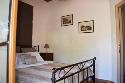 um quarto com uma cama e duas fotografias na parede em Taygetus apartments em Xirokámbion