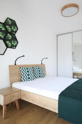 a bedroom with a large bed and a table at Apartament Szmaragdowy Platan in Kołobrzeg