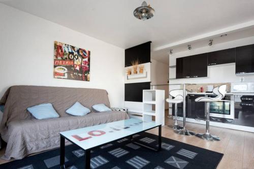 a living room with a couch and a table at MAISON *** AVEC COUR 3KM PLAGE ET LA ROCHELLE in Saint-Vivien