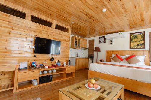 a bedroom with a bed and a tv in a room at SaPa Retreat Condotel in Sa Pa