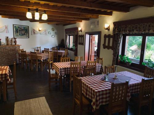 a dining room with tables and chairs in a restaurant at Székely Fogadó - Hanul Secuiesc in Băile Tuşnad