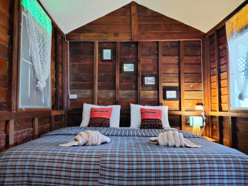 een slaapkamer met een bed met twee handdoeken erop bij พืชไทยเชียงคาน(Plantthai) in Chiang Khan
