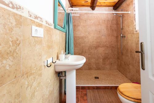 y baño con lavabo, ducha y aseo. en Karma House, en Casares